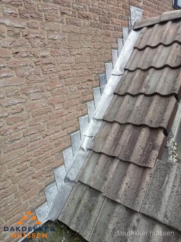 Loodslabben langs dakaansluiting bij bakstenen muur in Huissen