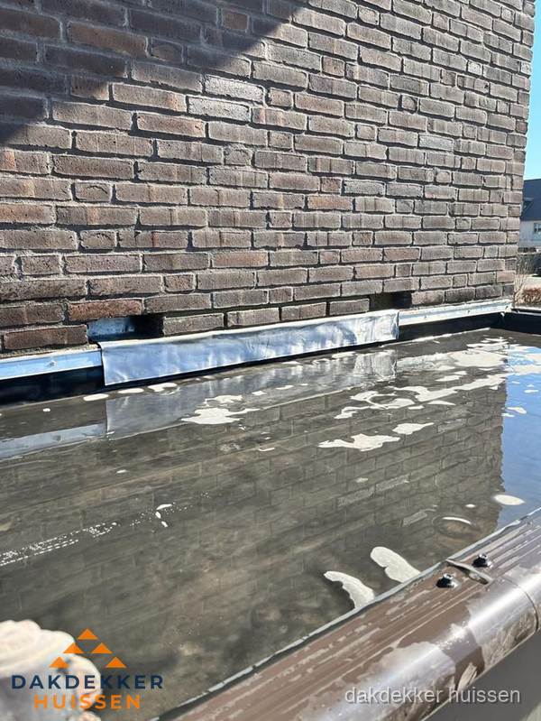 Stilstaand water op plat dak door slechte afwatering in Huissen