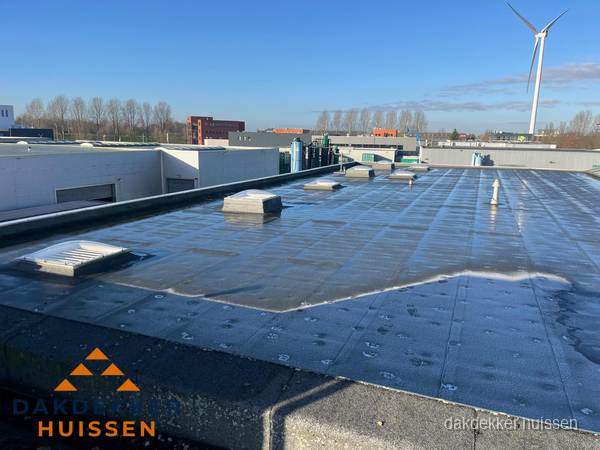 Plat dak bedrijfspand met bitumen dakbedekking en lichtkoepels in Huissen