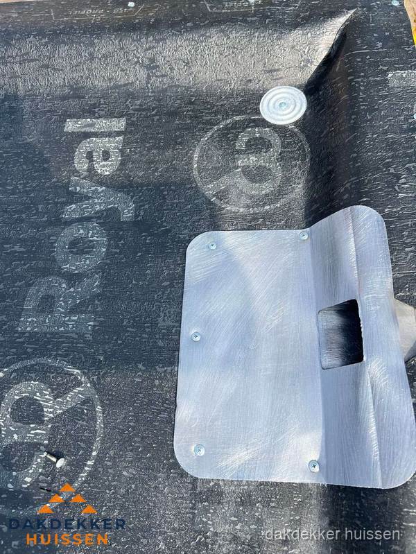 Dakdoorvoer met metalen afvoerplaat op bitumen dak in Huissen