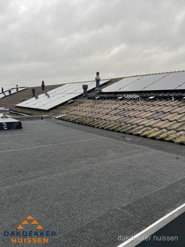 Bitumen dakbedekking op plat dak met aansluitend pannendak en zonnepanelen in Huissen