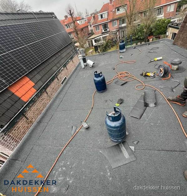 Daklekkage repareren met brandgereedschap op plat dak in Huissen