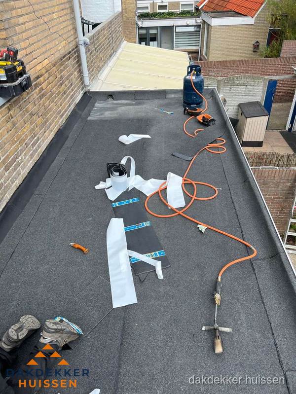 Dakdekkers bezig met bitumen dakbedekking in Huissen