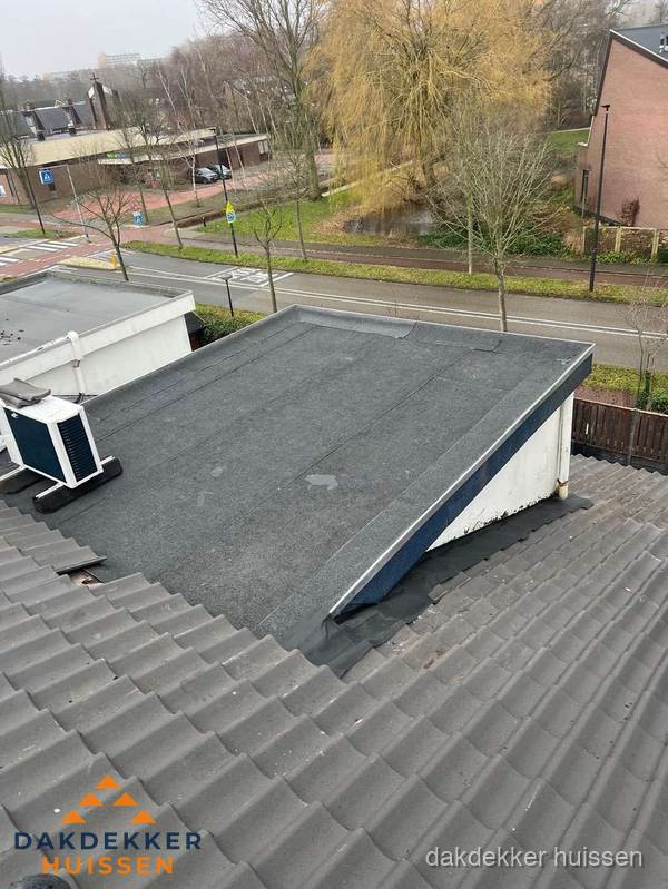 Plat dak met bitumen dakbedekking naast schuin pannendak in Huissen