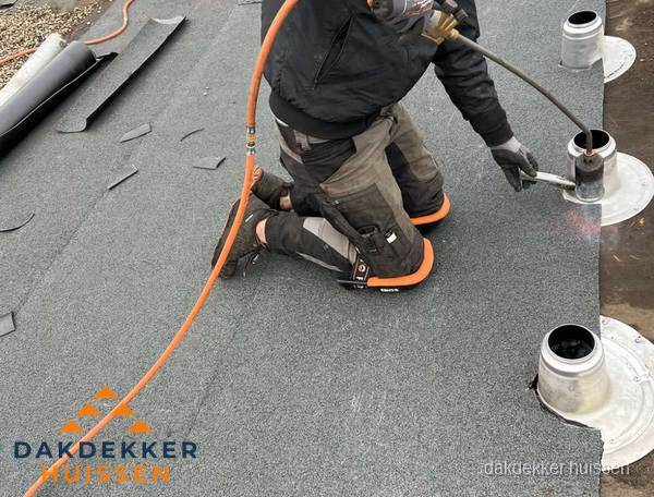 Dakdekker repareert bitumen dakleer bij dakdoorvoer in Huissen
