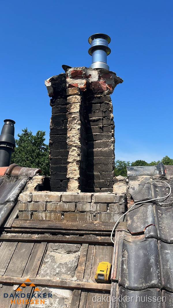 Beschadigde schoorsteen met nieuwe rookgasafvoer op oud dak in Huissen