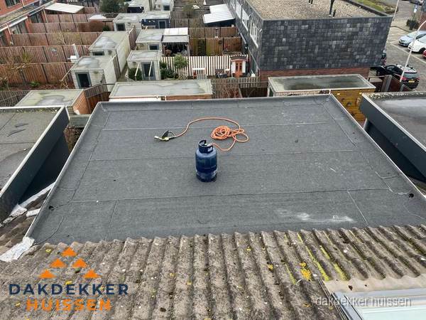 Plat dak met nieuwe bitumen dakbedekking en brandgereedschap in Huissen