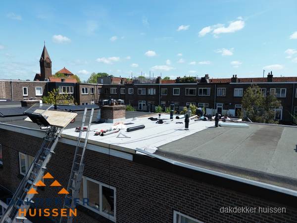 Dakdekkers aan het werk op plat dak in Huissen
