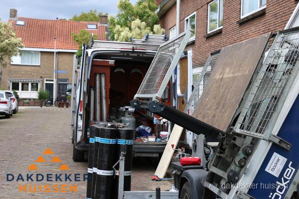 Dakdekkersbusje met materiaal en ladderlift voor dakpannen vervangen in Huissen